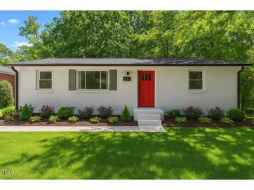 Charming single-story home with a bright red front door and well-manicured landscaping at 833 Brigham Rd, Raleigh, NC 27610