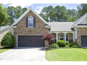 Charming home featuring stone accents, a two-car garage, well-manicured lawn, and a welcoming entrance at 120 Jennel Way, Durham, NC 27707