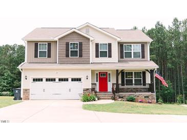 Charming two-story home with a bright red front door and well-manicured landscaping at 123 Scheer Ave, Durham, NC 27703