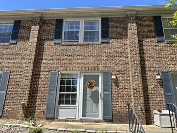 Charming brick townhome with blue shutters and a welcoming front entrance at 129 Friar Ln, Carrboro, NC 27510