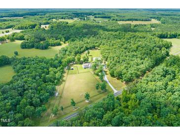 Sprawling estate showcasing a meticulously maintained home, surrounded by lush greenery and fenced pasture at 1717 Ormond Rd, Hurdle Mills, NC 27541