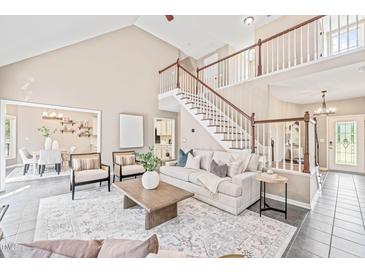 Bright living room with high ceilings, a staircase, and an open floor plan with a neutral color palette at 1717 Ormond Rd, Hurdle Mills, NC 27541