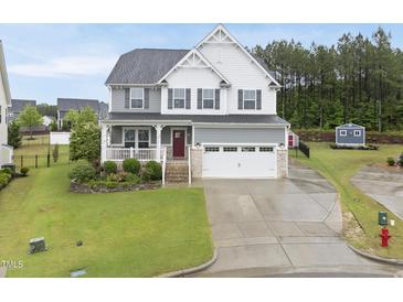 Charming two-story home featuring a white picket fence and a two-car garage with a manicured front yard at 2909 Landon Pines Ct, New Hill, NC 27562