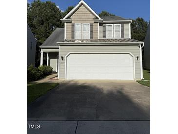 Home featuring a two-car garage, gray siding, and complementary brown accents at 4009 Patriot Ridge Ct, Raleigh, NC 27610