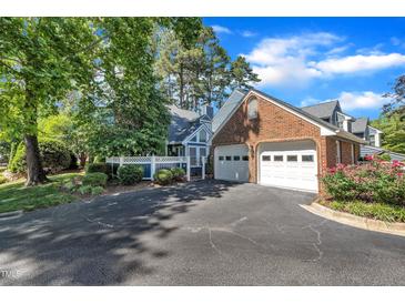 Inviting home with a two-car garage, well-kept lawn, and meticulously landscaped garden at 7601 Wellesley N Park, Raleigh, NC 27615