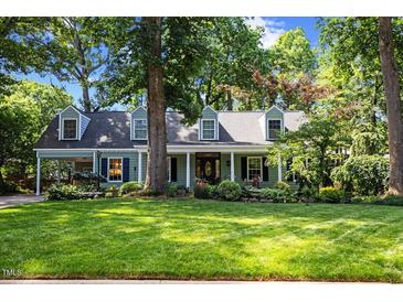 Charming single-Gathering home boasts a lush green lawn and mature trees, complete with a covered porch and traditional dormers at 924 Pebblebrook Dr, Raleigh, NC 27609