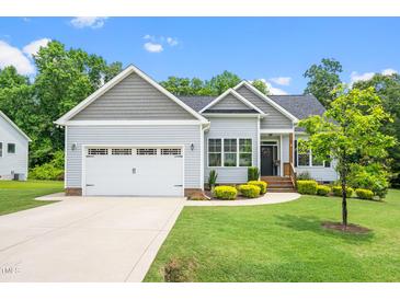 Charming single-Gathering home featuring manicured lawn, attached garage, and welcoming front porch at 115 Jensen Dr, Wendell, NC 27591