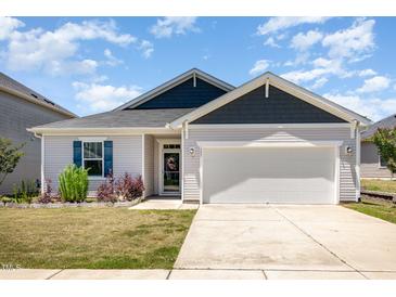 Charming single-story home with a two-car garage, and well-manicured lawn at 157 Willow Grove Ln, Fuquay Varina, NC 27526