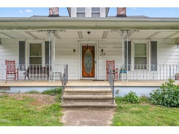 Inviting front porch with classic railings, seating, and a charming entryway leading to the home's entrance at 219 W Parker St, Graham, NC 27253