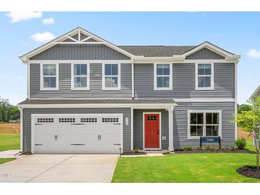 Charming two-story home with a two-car garage, red door, and manicured lawn at 220 Rosewood Dr, Sanford, NC 27330