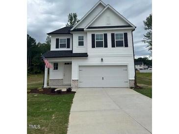 Charming two-story home with a two-car garage, white siding, and an American flag at 224 Wild Turkey Way, Lillington, NC 27546