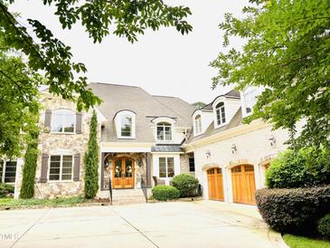 Stunning stone and brick home with a three-car garage and beautifully landscaped front yard at 5205 Newstead Manor Ln, Raleigh, NC 27606
