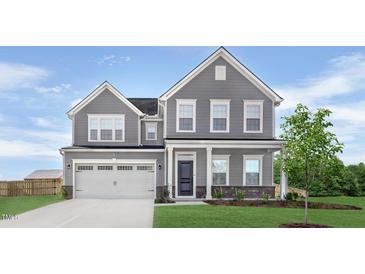 Charming two-story home featuring a well-manicured lawn and attached two-car garage at 61 Lismore St, Sanford, NC 27330