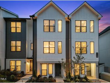 Modern townhome featuring black trim, light brick accents, and a beautifully landscaped front yard at 710 W North St # 101, Raleigh, NC 27603