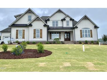 Stunning two-story home featuring beautiful wood shutters, a manicured lawn and meticulous landscaping at 90 Water Willow Ln, Zebulon, NC 27597