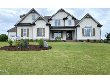 Stunning two-story home with light siding, brown shutters, manicured lawn and attractive landscaping at 90 Water Willow Ln, Zebulon, NC 27597