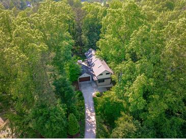 Stunning aerial view of home nestled among lush green trees with a private driveway at 9021 Albatross Ct, Raleigh, NC 27613