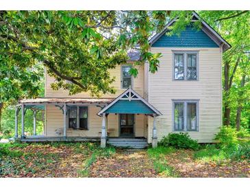 Charming two-story home with a covered porch and mature trees in a residential neighborhood at 903 Nicholas St, Henderson, NC 27536