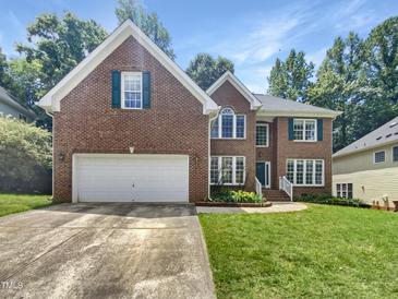 Charming two-story brick home with a well-manicured lawn, an attached two-car garage, and beautiful green window shutters at 105 Crosswaite Way, Cary, NC 27518