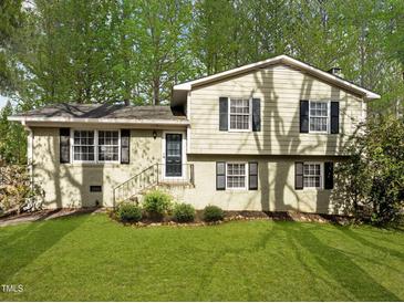 Charming split-level home with a well-manicured lawn and mature trees providing ample shade at 1195 Champion Dr, Cary, NC 27511