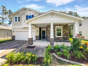Charming home with stone accents, covered front porch, and beautifully landscaped front yard at 148 Daneborg Rd, Durham, NC 27703