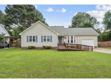 Charming single-story home featuring a ramp to the front door, complemented by lush green lawn and mature trees at 1609 Forest Rd, Wake Forest, NC 27587