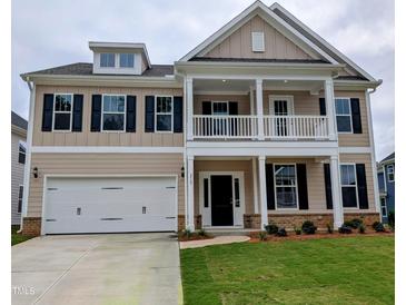 Two-story home boasts a charming front porch, a two-car garage, and a well-manicured lawn at 212 Augusta Pond Way # 128, Raleigh, NC 27603