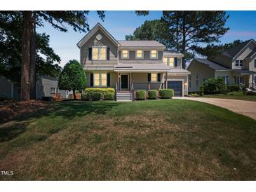 Charming two-story home with a well-manicured lawn and inviting front porch at 5505 Pennfine Dr, Raleigh, NC 27610