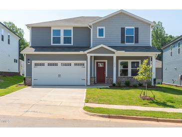 Charming two-story home featuring a two-car garage, covered porch, and well-manicured lawn at 713 Deschutes Dr, Garner, NC 27529
