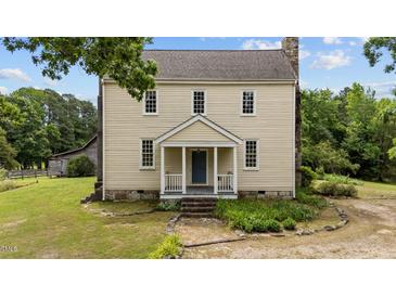 Charming two-story historic home featuring a welcoming front porch and well-maintained landscaping at 7404 Halifax Rd, Youngsville, NC 27596