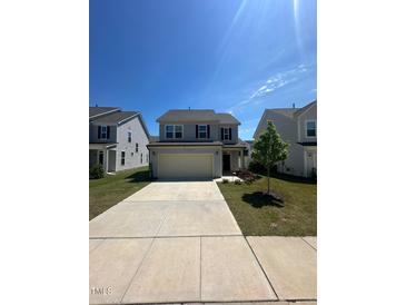 Charming two-story home featuring a two-car garage and a well-manicured front yard at 99 Still Hand Dr, Clayton, NC 27527