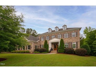 Stately brick home boasts dormer windows, manicured landscaping, and a welcoming entrance at 119 Eagles Watch Ln, Chapel Hill, NC 27517