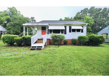 Charming single-story home with white siding, orange door, and well-maintained front yard at 2006 N Ashland Dr, Burlington, NC 27217