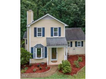 Charming two-story home with manicured landscaping, featuring a bay window and inviting front porch at 4009 Olde Coach Rd, Durham, NC 27707