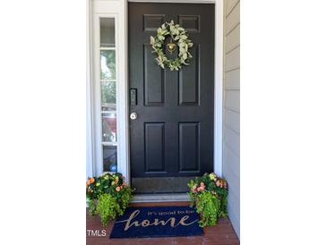 Charming home features a black front door adorned with a wreath and welcome mat at 4905 Knightsbridge Way, Raleigh, NC 27604