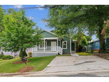 Charming green home featuring a cozy front porch with white railing and a well-manicured lawn at 507 N Elm St, Durham, NC 27701