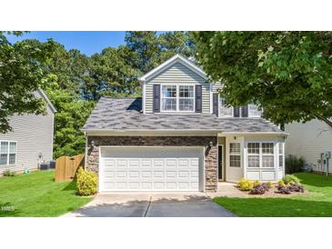 Home featuring a two-car garage, stone accents, and a well-manicured lawn at 6 Beaver Creek Lane Ln, Durham, NC 27703