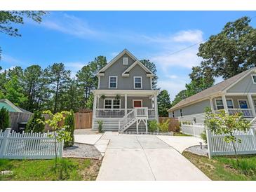 Charming two-story home featuring a welcoming porch, manicured lawn, and a concrete driveway at 647 N Hardee St, Durham, NC 27703