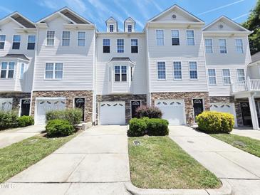 Beautiful townhouses with a well-manicured lawn and individual driveways on a sunny day at 650 Ganyard Farm Way # 41, Durham, NC 27703