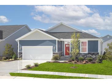 Charming single-story home featuring a red front door, stone accents, and a well-manicured lawn at 904 Emmer St, Rolesville, NC 27571