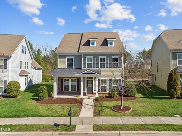 Charming two-story home with a manicured lawn, complemented by black shutters and a welcoming front porch at 1144 Survada Ln, Morrisville, NC 27560