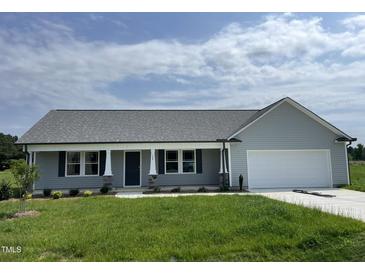 Charming single-story home with gray siding, manicured lawn, and attached two-car garage at 148 Coharie Dr, Lillington, NC 27546