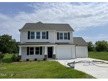 Charming two-story home featuring a two-car garage and well-manicured lawn at 186 Coharie Dr, Lillington, NC 27546
