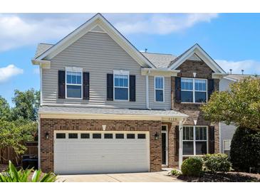 Charming two-story home with brick and vinyl siding, a two-car garage, and well-maintained landscaping at 2128 Feather Ridge Dr, Holly Springs, NC 27540