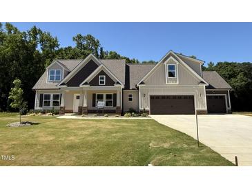 Charming two-story home with a well-manicured lawn and a two-car garage at 217 Busterfield Ct, Benson, NC 27504