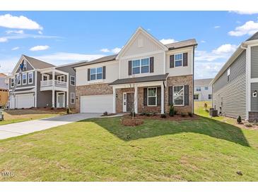 Charming two-story home with a well-manicured lawn, brick facade, and a welcoming front porch at 257 North Maple Walk Dr # 218, Garner, NC 27529