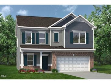 Charming two-story home with brick accents, a welcoming front porch, and a two car garage at 32 Freedom Heights Ln # 151, Smithfield, NC 27577