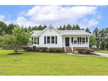 Charming single-story home with white siding, manicured lawn and mature landscaping at 366 E Smithfield St, Angier, NC 27501