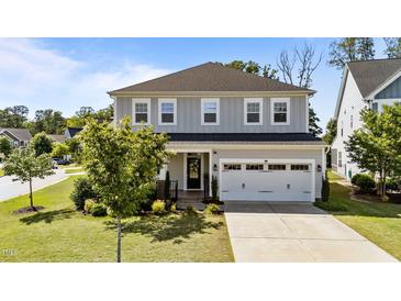 Charming two-story home with a gray exterior, a two-car garage, and a beautifully landscaped front yard at 408 Torwood Cir, Apex, NC 27523