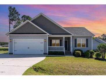 Charming single-Gathering home with a two-car garage, landscaped lawn, and covered front porch at 41 Tan Oak Dr, Selma, NC 27576